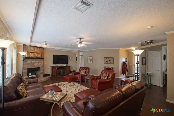 a living room with furniture a fireplace and a flat screen tv