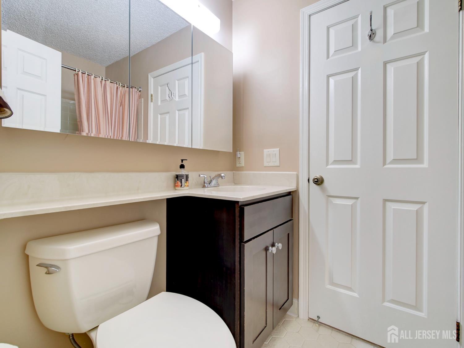136 Wycoff Way West East Brunswick, NJ 08816 - Photo 18 of 28 a bathroom with a toilet sink and mirror