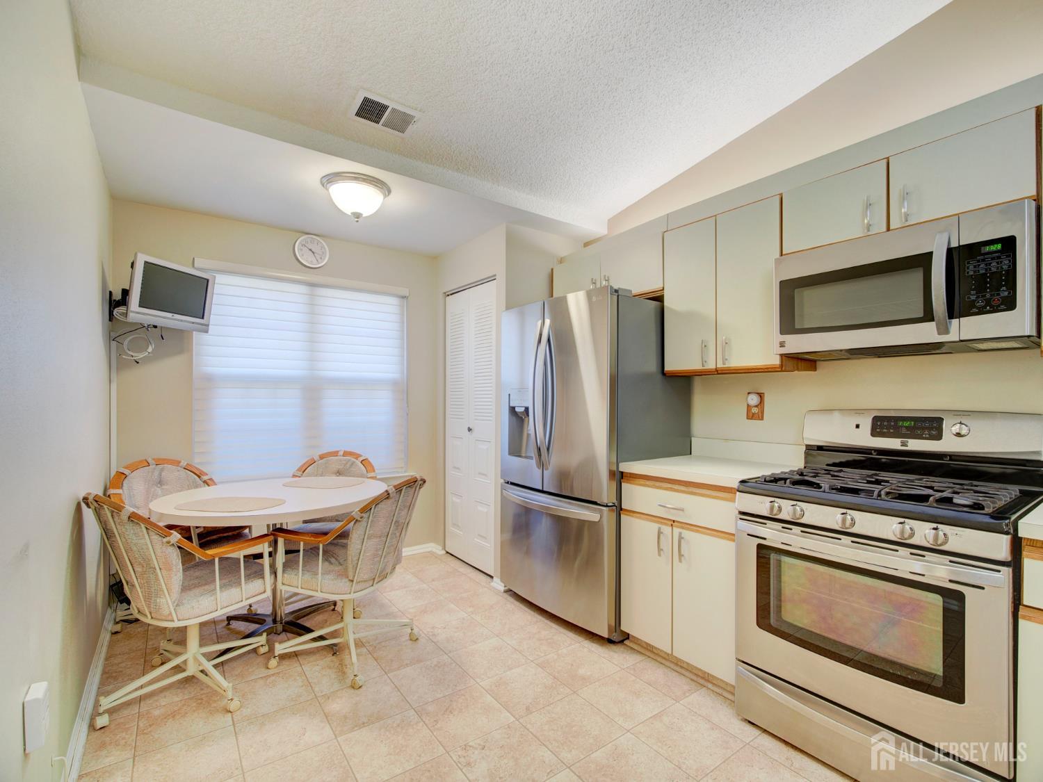 136 Wycoff Way West East Brunswick, NJ 08816 - Photo 9 of 28 a kitchen with stainless steel appliances a refrigerator and a stove top oven