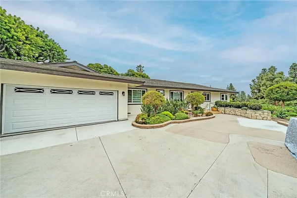 front view of a house with a yard and potted plants