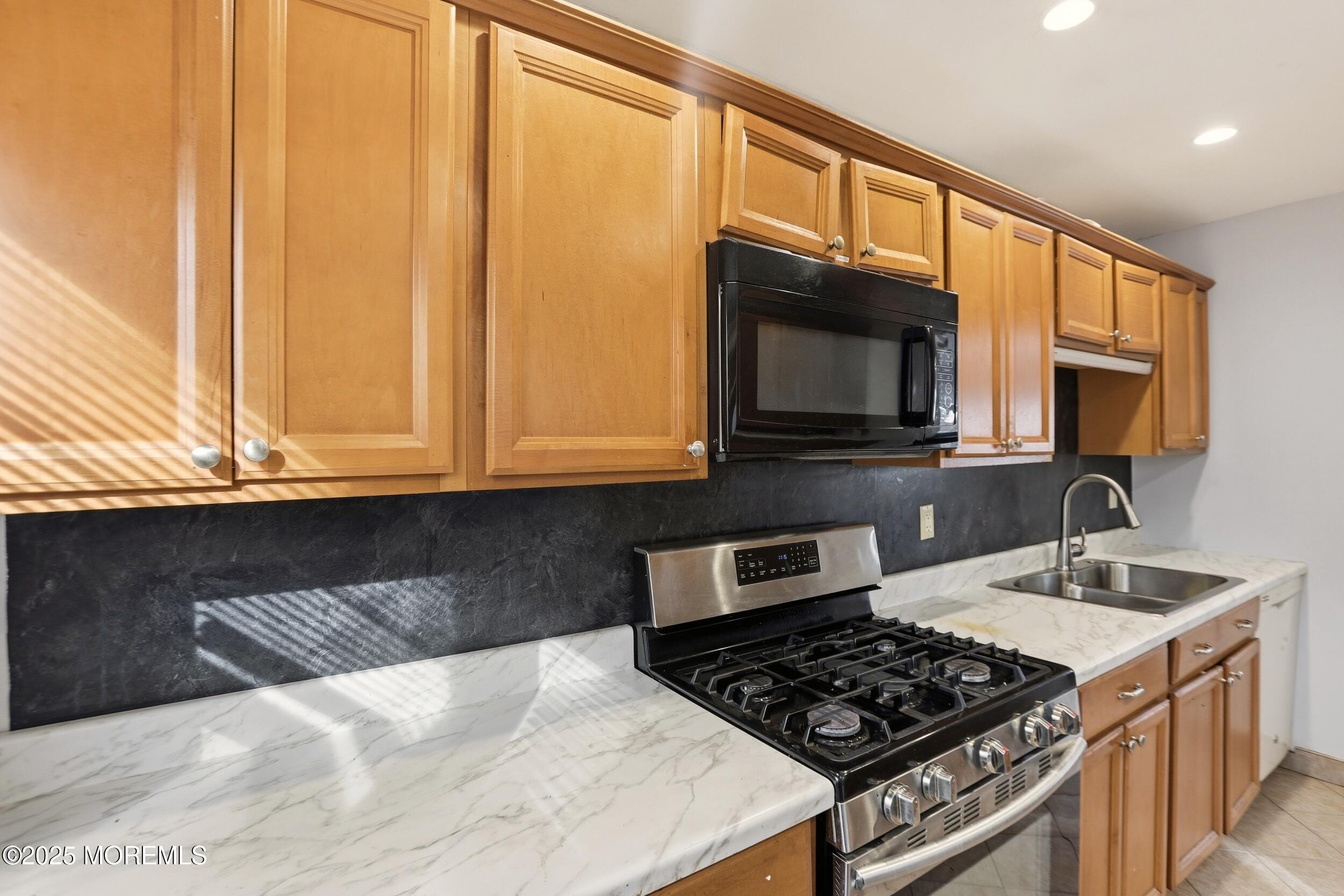 7 Citadel Court Jackson, NJ 08527 - Photo 12 of 29 a kitchen with stainless steel appliances a stove a sink and a microwave