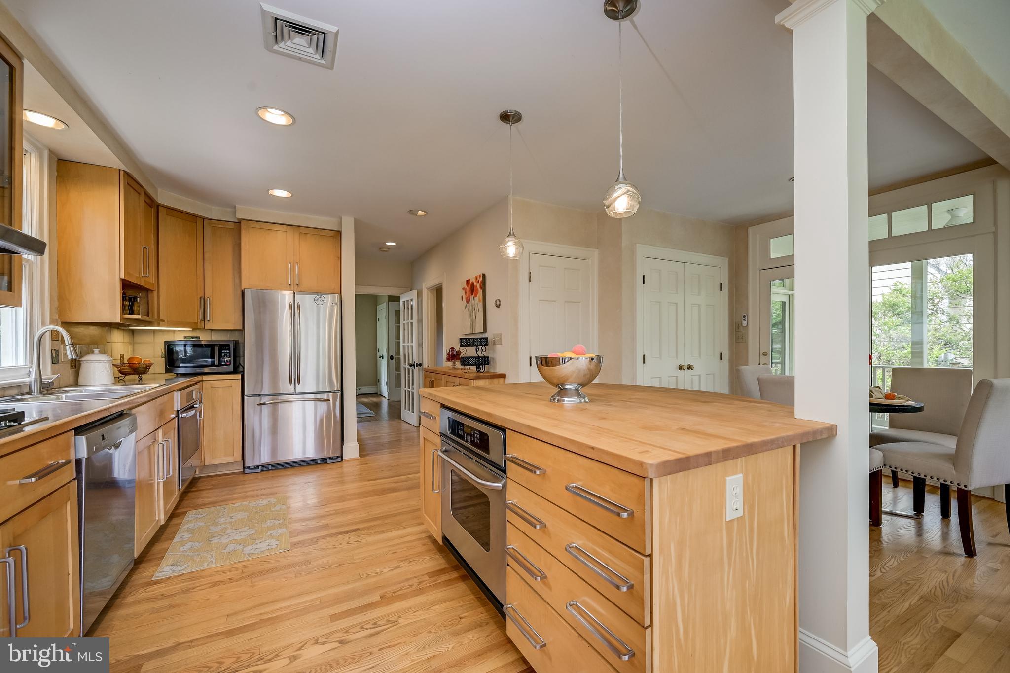 3608 Spring Street Chevy Chase, MD 20815 - Photo 14 of 38 a kitchen with stainless steel appliances granite countertop a sink a stove a refrigerator and island with wooden floor