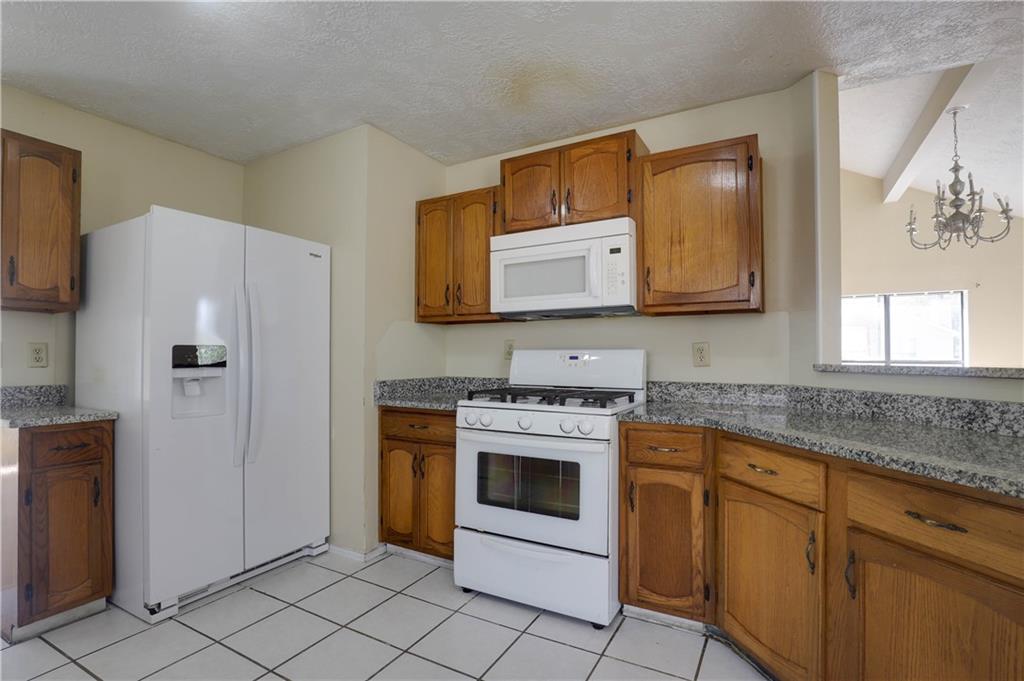 7043 Ivy Pointe Row Austell, GA 30168 - Photo 11 of 36 a kitchen with stainless steel appliances granite countertop a stove a refrigerator and a microwave