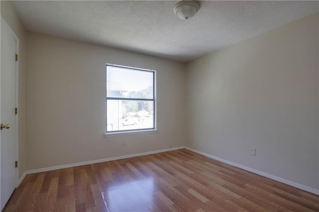 7043 Ivy Pointe Row Austell, GA 30168 - Photo 18 of 36 an empty room with wooden floor and windows