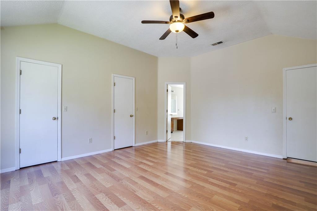7043 Ivy Pointe Row Austell, GA 30168 - Photo 24 of 36 an empty room with wooden floor fan and windows
