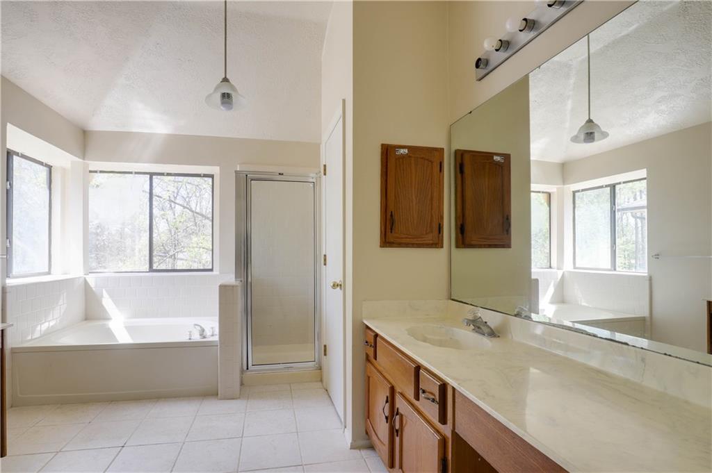 7043 Ivy Pointe Row Austell, GA 30168 - Photo 26 of 36 a bathroom with a tub sink and mirror