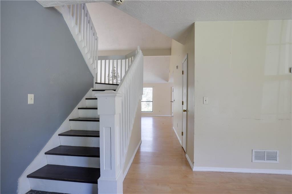 7043 Ivy Pointe Row Austell, GA 30168 - Photo 3 of 36 a view of staircase with wooden floor and white walls