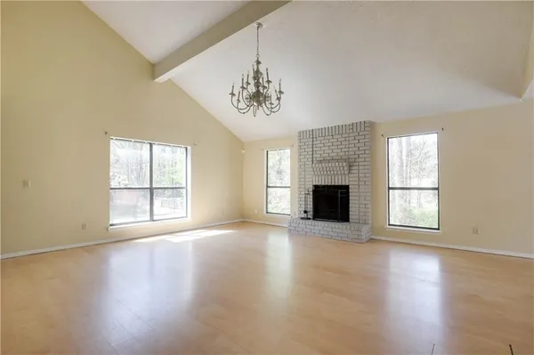 an empty room with windows and fireplace