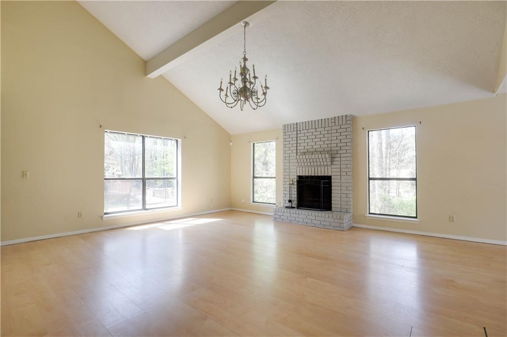 7043 Ivy Pointe Row Austell, GA 30168 - Photo 6 of 36 an empty room with wooden floor fireplace and windows
