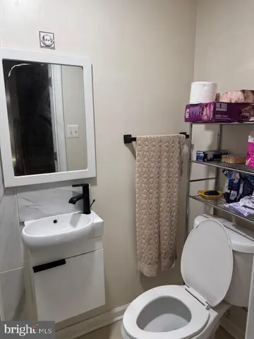 a bathroom with a toilet sink and mirror