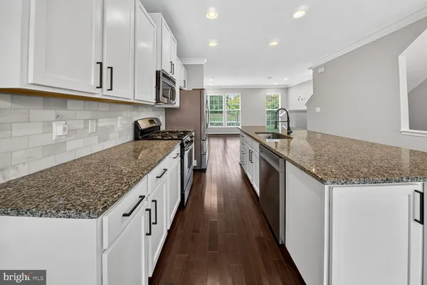 a kitchen with granite countertop sink stainless steel appliances and a counter space