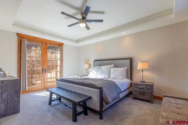 a bedroom with a bed a chandelier and a window