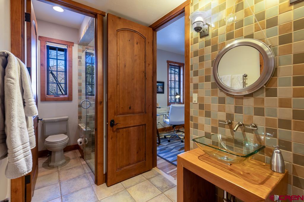 80 Twilight Trails Circle Durango, CO 81301 - Photo 20 of 35 a bathroom with a granite countertop toilet a sink and a mirror