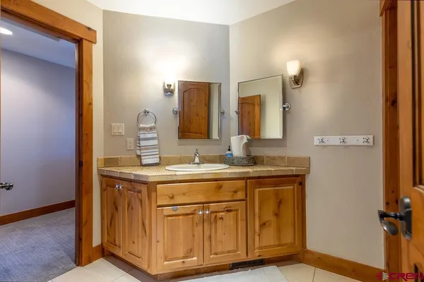 a bathroom with a granite countertop sink and a mirror