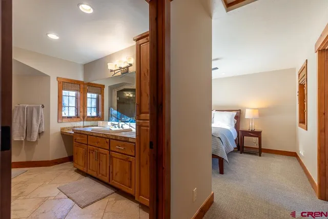 a spacious bathroom with a granite countertop sink and a mirror