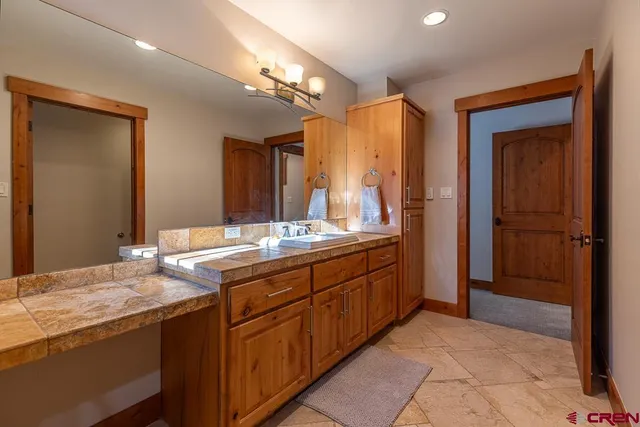 a bathroom with a granite countertop sink and a mirror
