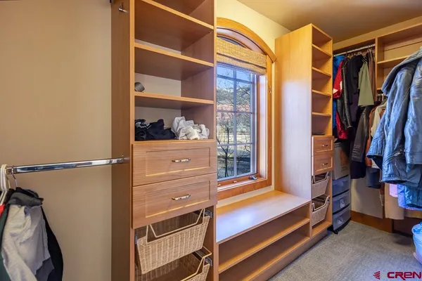 a view of walk in closet with clothes and shoes