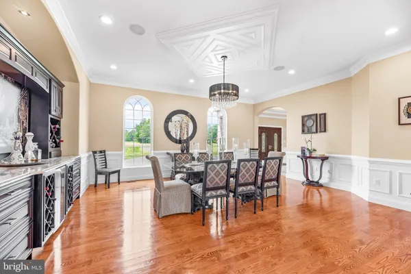 a kitchen with stainless steel appliances kitchen island granite countertop a table chairs a sink and dishwasher a refrigerator with wooden floor