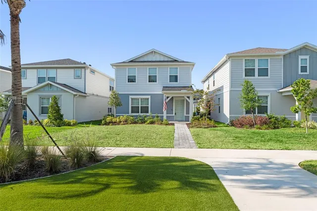 a front view of a house with a yard and trees