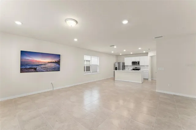 a view of an empty room with window and cabinet
