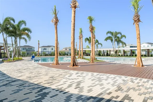 a view of a swimming pool with a house and palm trees