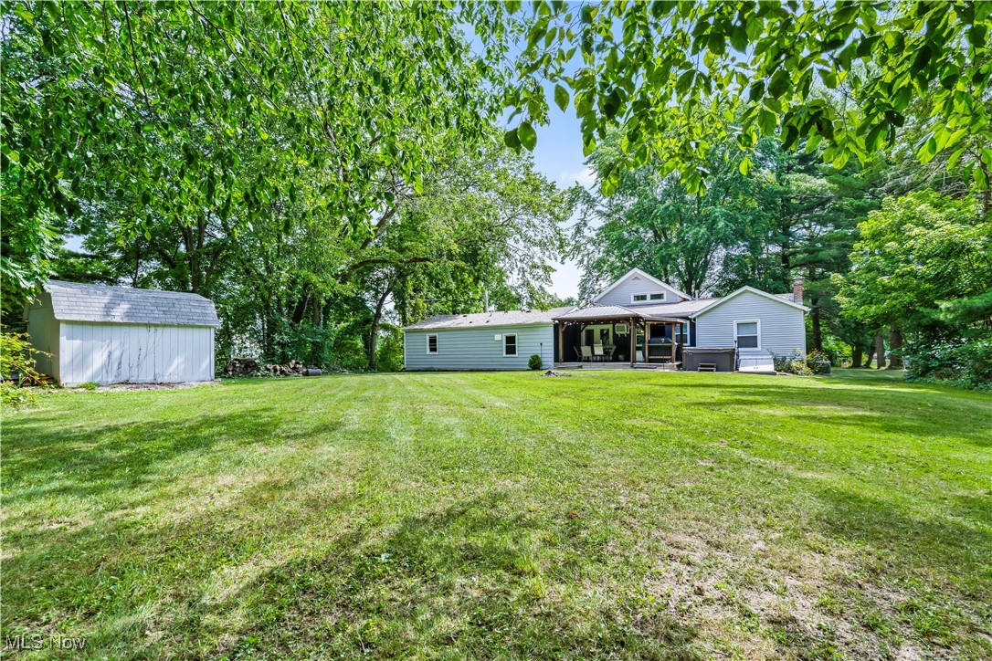 6170 Oberlin Road Amherst, OH 44001 - Photo 14 of 39 View of green lawn featuring a sunroom and a storage unit