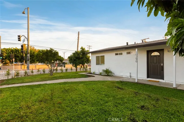 a view of a house with a yard and potted plants