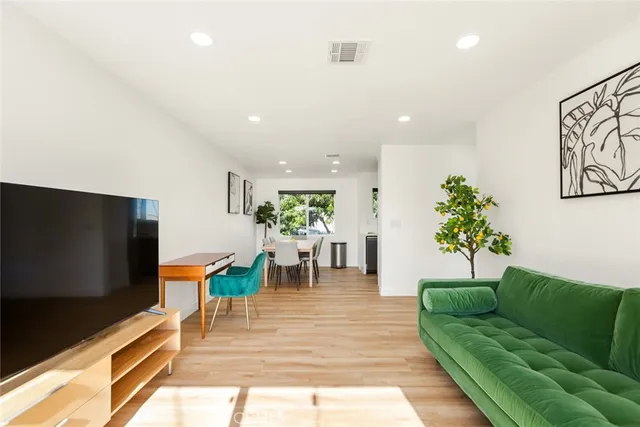 a living room with furniture a dining table and a potted plant