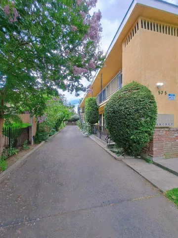 a view of a street with a house in the background