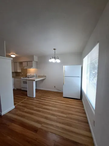 a view of a kitchen with wooden floor and a ceiling fan