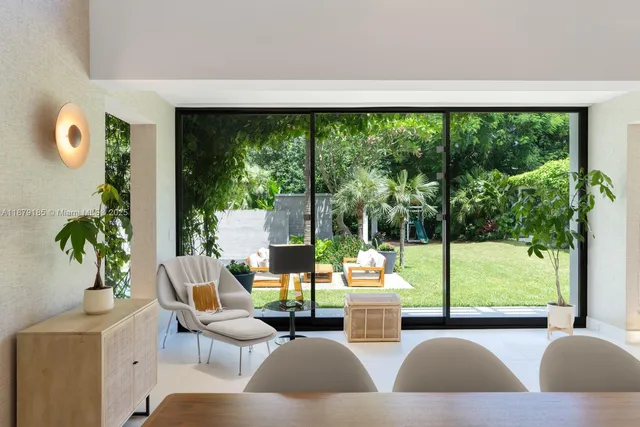 a living room with patio furniture and a potted plant