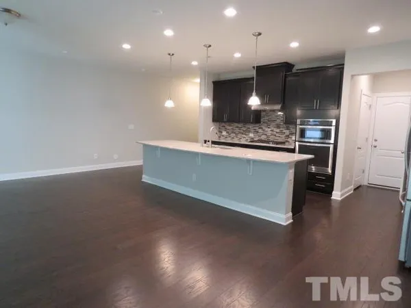 a large kitchen with stainless steel appliances a large counter top