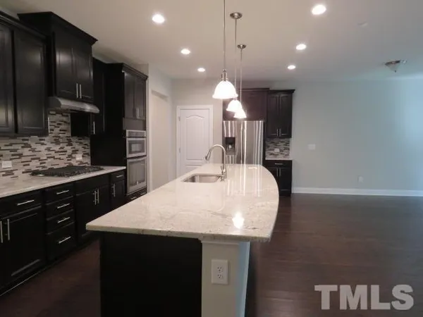 a kitchen with a sink a counter space appliances and cabinets