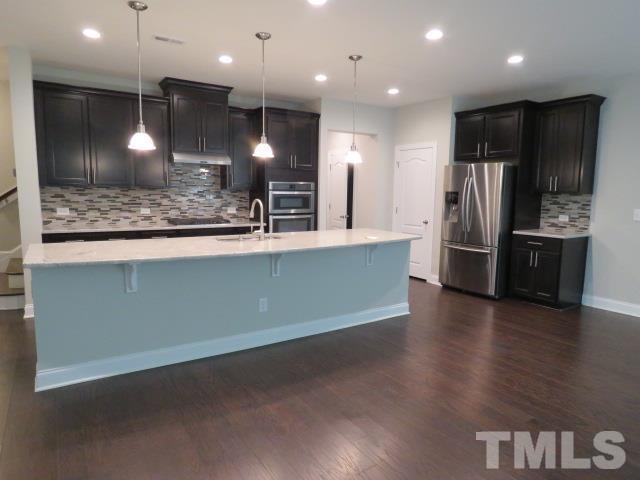 1517 Catch Fly Lane Durham, NC 27713 - Photo 9 of 44 a large kitchen with stainless steel appliances kitchen island a large counter top and a refrigerator