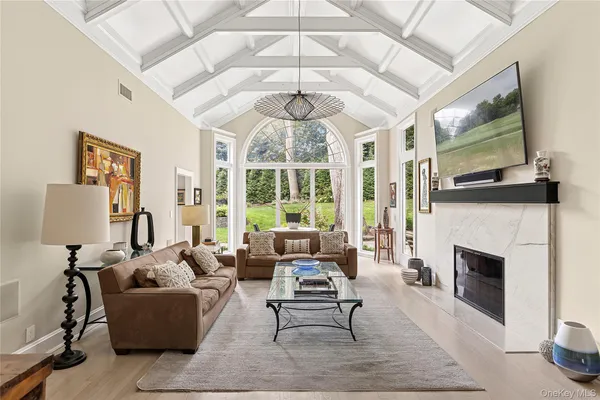 a dining room with furniture a chandelier and wooden floor