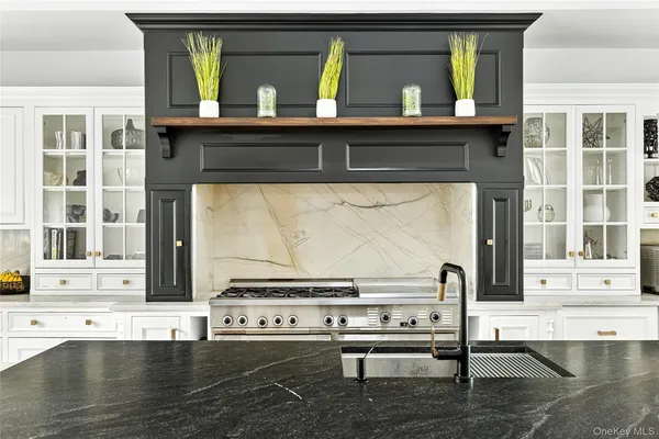 a dining hall with stainless steel appliances kitchen island granite countertop a table chairs and a view of living room