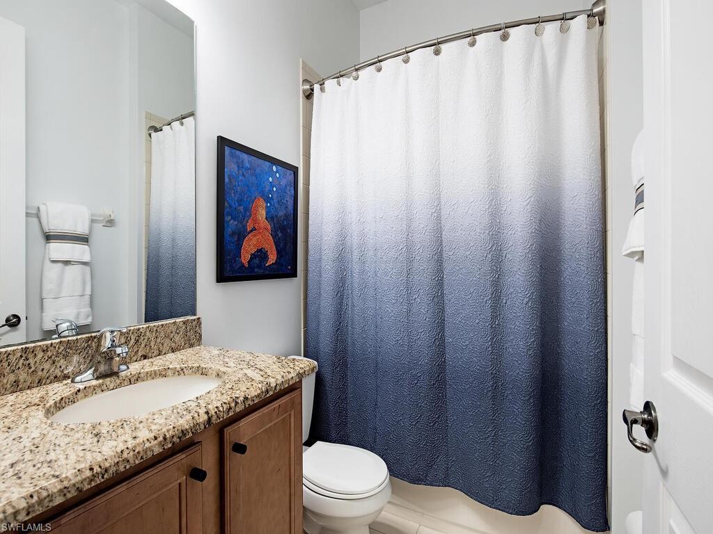 3487 Pacific Drive Naples, FL 34119 - Photo 13 of 33 a bathroom with a granite countertop sink and a mirror