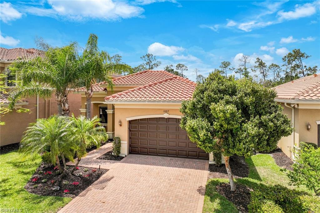 3487 Pacific Drive Naples, FL 34119 - Photo 17 of 33 a front view of a house with a yard and garage
