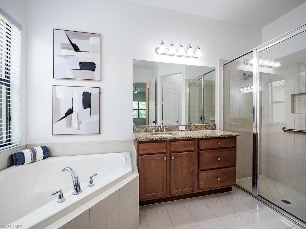 3487 Pacific Drive Naples, FL 34119 - Photo 10 of 33 a bathroom with a tub a sink and mirror