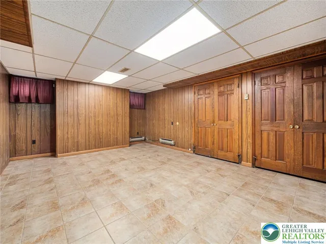 an empty room with windows and ceiling fan