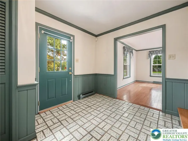 an empty room with wooden floor fireplace and windows