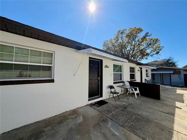 a view of a house with backyard porch and sitting area