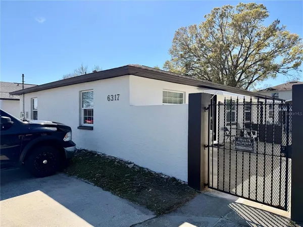 a view of backyard of house and car parked