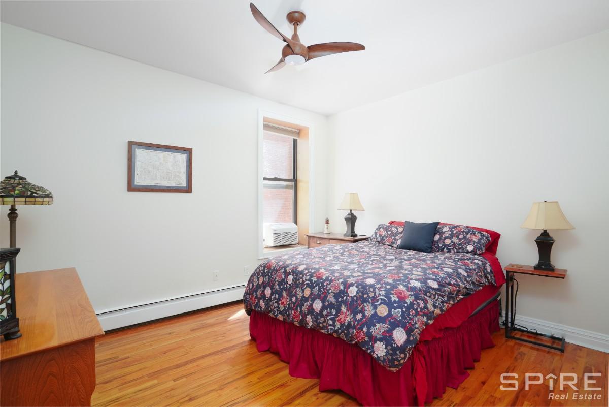 370 St Nicholas Avenue, Unit 5B Manhattan, NY 10027 - Photo 14 of 23 a bedroom with a bed and wooden floor