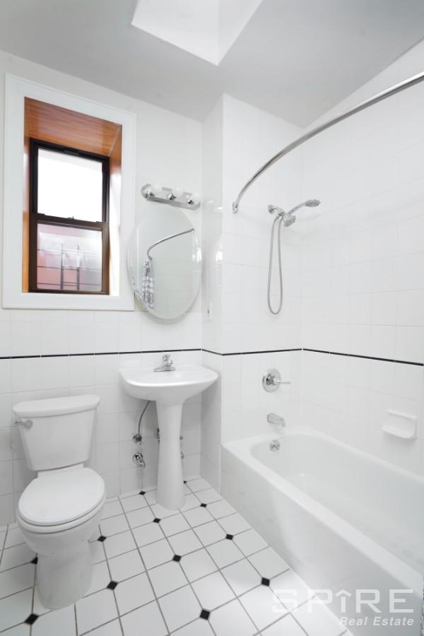 370 St Nicholas Avenue, Unit 5B Manhattan, NY 10027 - Photo 16 of 23 a bathroom with a sink a toilet and shower