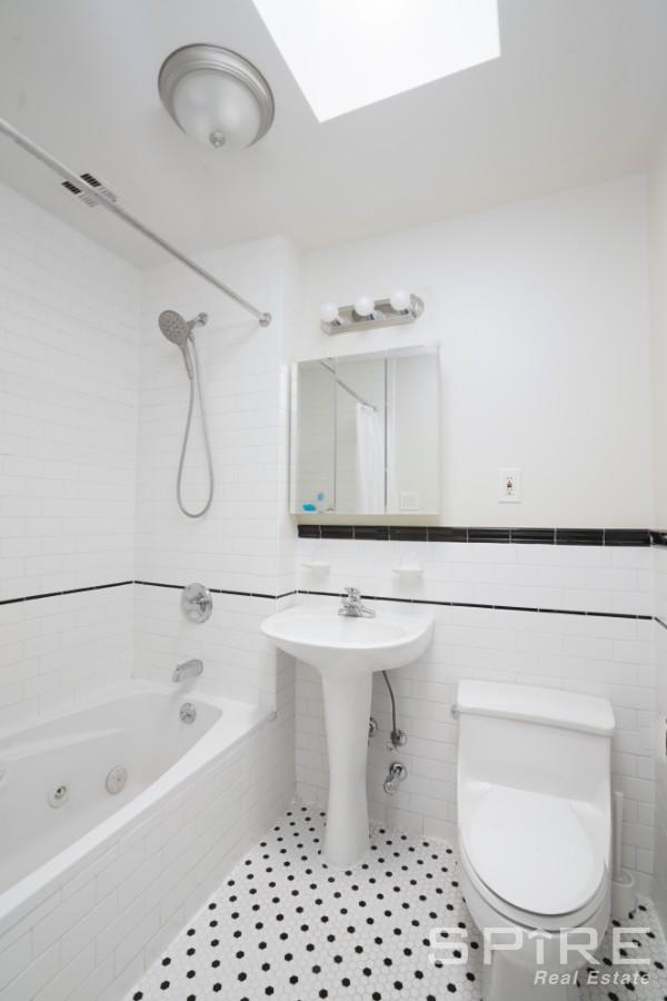 370 St Nicholas Avenue, Unit 5B Manhattan, NY 10027 - Photo 19 of 23 a bathroom with a sink a toilet and a bathtub