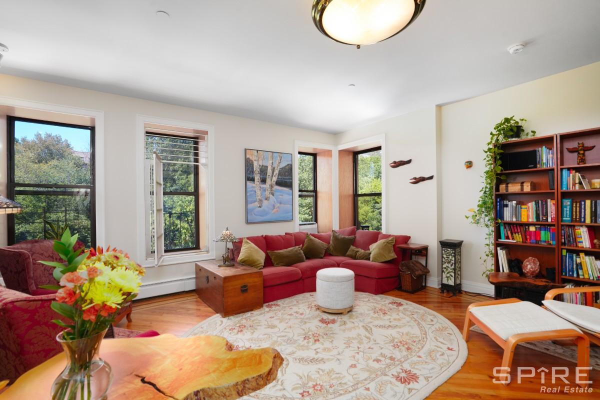 370 St Nicholas Avenue, Unit 5B Manhattan, NY 10027 - Photo 2 of 23 a living room with furniture and a book shelf