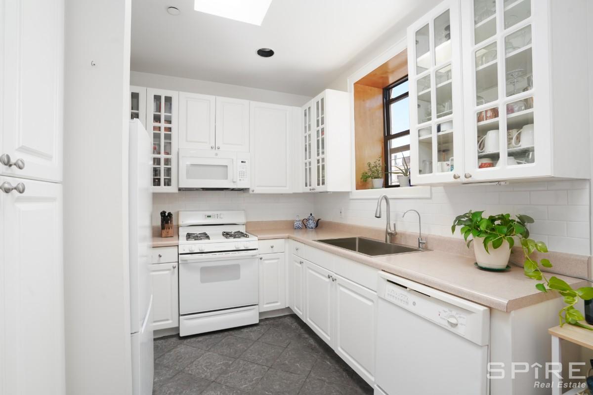 370 St Nicholas Avenue, Unit 5B Manhattan, NY 10027 - Photo 6 of 23 a kitchen with a sink cabinets and window
