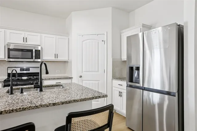 a kitchen with sink and view living room
