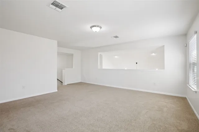 an empty room with a window and wooden floor